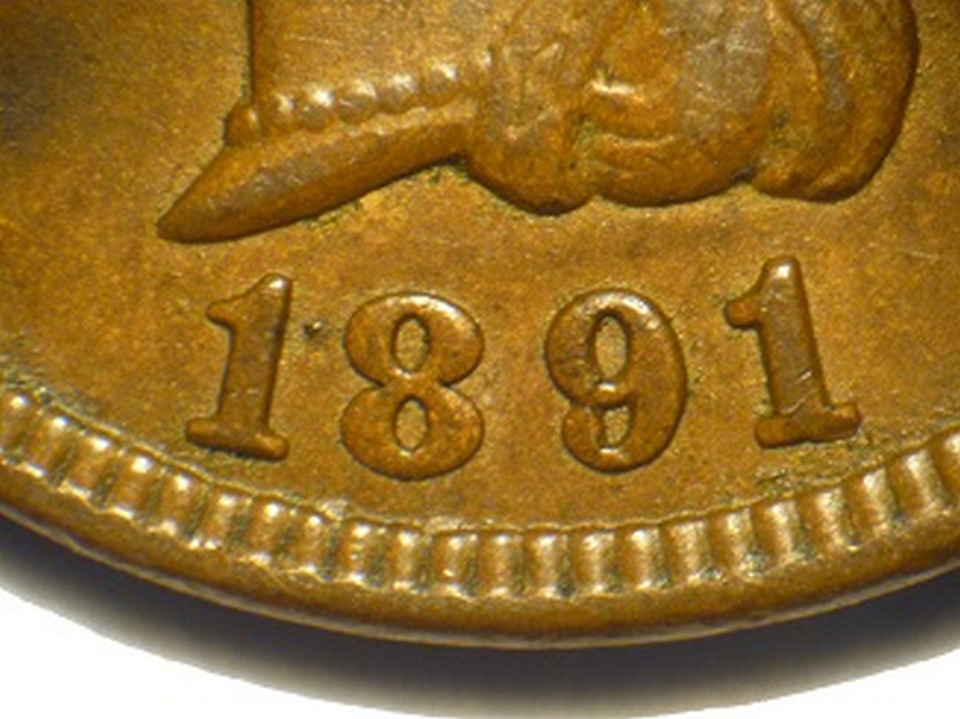 Close-up of 1891 Indian Head Penny repunched date showing doubled digit outlines under magnification